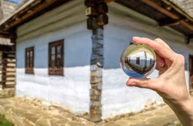 Crystal lensball and rural cottages in musem of the Slovak villa clipart
