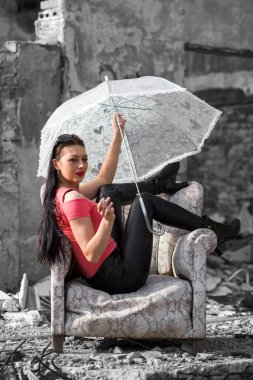 Sandalyede oturan şemsiye ile güzel kız
