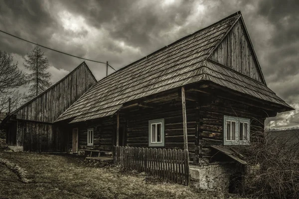 Old cottage and dark clouds — Stock Photo, Image