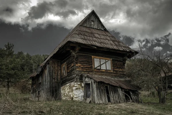 Old cottage and dark clouds — Stock Photo, Image