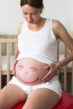 Hamile karnında gülen emoji.