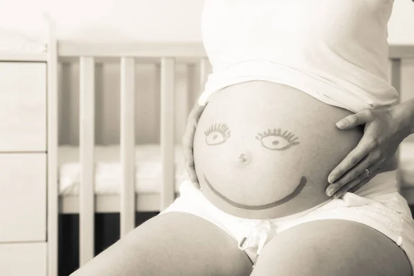 Lächelndes Emoji auf schwangerem Bauch — Stockfoto