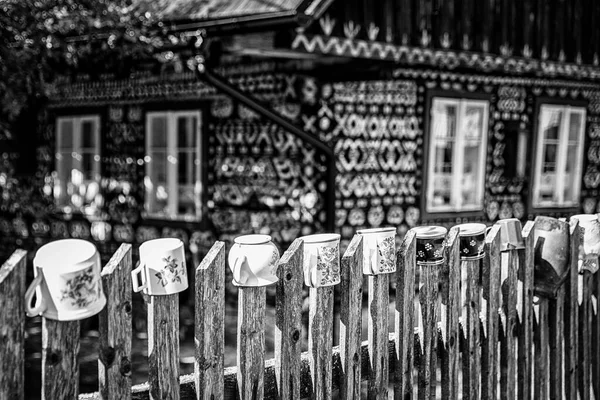 村の木造コテージの前のフェンスの上にクレイヴィンテージポット Cikmany Survia — ストック写真
