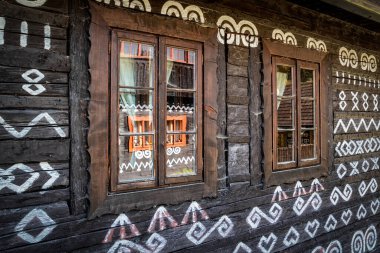Slovakya 'nın UNESCO köyü Cicmany' deki süs boyalarıyla yazlık evin camlarında yansıma.