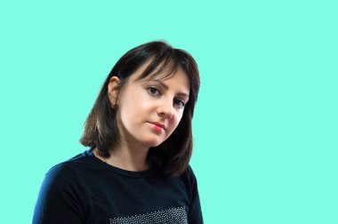 Genç güzel bir kadının portresi, minimal makyaj, doğallık ve güzellik ile pürüzsüz sağlıklı bir cilt. Açık yeşil arka planda büyüleyici esmer