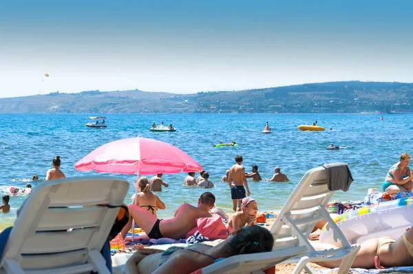 Kumsalda güneşlenenler ve tatilciler. Ukrayna. Kırım. Theodosius. Temmuz 2019.