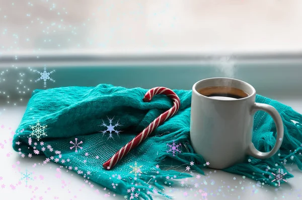 Pencere kenarında bir kupa sıcak kahve var. Yakınlarda kızgın mavi bir eşarp ve lolipop şekeri yatıyor.