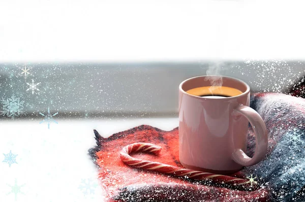 Pencere kenarında bir kupa sıcak kahve var. Yakınlarda kızgın mavi bir eşarp ve lolipop şekeri yatıyor.