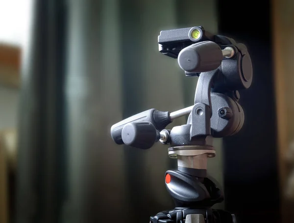 Kamera için yüksek kalite 3 eksenli tripod baş. Pencerenin karşısındaki bir tripoda bağlı.