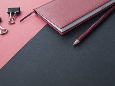 Ofis, banka donatımı: kırmızı bir not defteri, kalem ve kağıt kırpmak üstünde siyah bir arka plan. Üstten Görünüm. Kopya alanı.