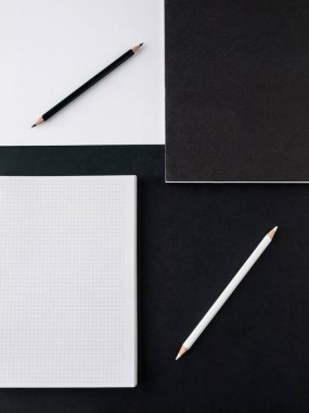 Ofis konsepti. Siyah ve beyaz kalem, boş defter ve siyah ve Beyaz Kağıt arka planda kara dergi. Üst görünüm. Boşluk Kopyala
