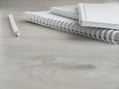 Boş notebooklar ve tahta gri masada bir kalem. Okula dönüyoruz. Üst görünüm. Boşluk Kopyala