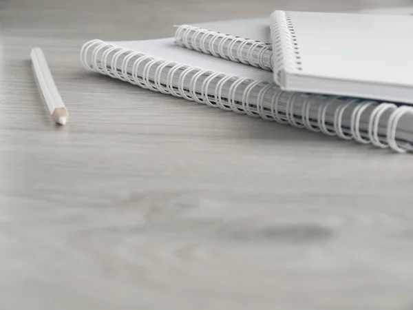 Cuadernos vacíos y un lápiz sobre una mesa gris de madera. De vuelta a la escuela. Vista superior. Copiar espacio — Foto de Stock