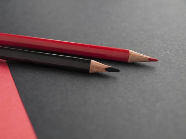 Accessoires de bureau : crayon noir, crayon rouge sur fond noir, rouge. Vue de dessus. Espace de copie — Photo