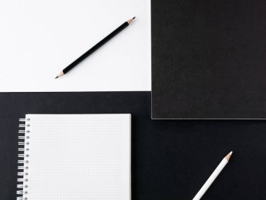 Ofis konsepti. Siyah ve beyaz kalem, boş defter ve siyah ve Beyaz Kağıt arka planda kara dergi. Üst görünüm. Boşluk Kopyala