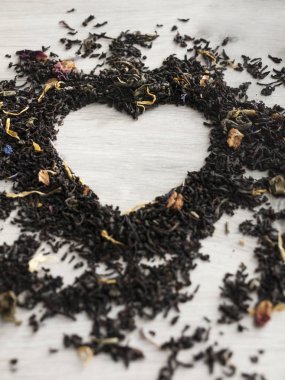Çay kavramı. Ahşap gri masada bir kalp şeklinde çiçek kuru çay. Sevgililer günü. Aşık. Üst görünüm. Boşluk Kopyala