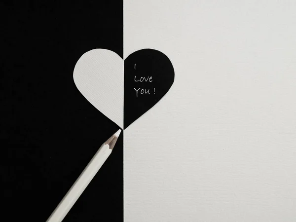 Declaration of love. Valentine\'s Day. Heart, pencil, inscription on white, black background. Yin Yang. View from above. Copy space