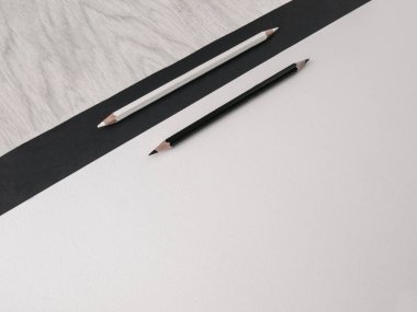 Ofis aksesuarları: siyah ve beyaz karton, ahşap gri masa üzerinde siyah ve beyaz kalemler. Eğitim. Finans. Iş. Üst görünüm. Boşluk Kopyala