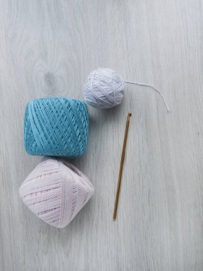 Örme için her şey: mavi ve pembe iplik skeins ve gri ahşap masada bir tığ kanca. Üst görünüm Kopyala alanı