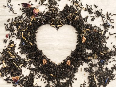 Çay kavramı. Ahşap gri masada bir kalp şeklinde çiçek kuru çay. Sevgililer günü. Aşık. Üst görünüm. Boşluk Kopyala