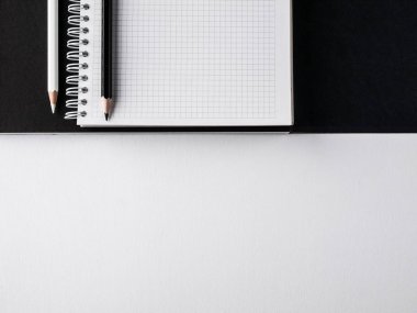 Ofis konsepti. Siyah ve beyaz kalem, boş defter ve siyah ve Beyaz Kağıt arka planda kara dergi. Üst görünüm. Boşluk Kopyala