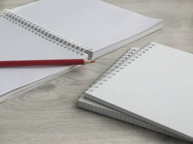 Boş notebooklar ve tahta gri masada bir kalem. Okula dönüyoruz. Üst görünüm. Boşluk Kopyala