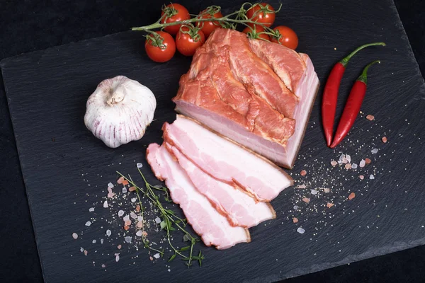 Bacon fumado na placa de pedra preta — Fotografia de Stock