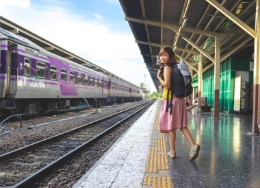 bir gezgin, backpacker Bayan ayakta rahat kıyafetler ve bekleyen bir tren platformu için Tren İstasyonu