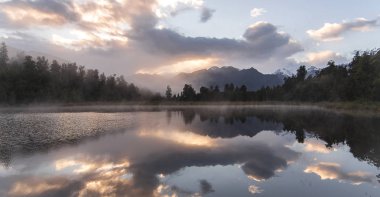 Hala göl Matheson Yeni Zelanda yeşil çam ormanı, sabah bulut gökyüzü ve dağ yansıtmak