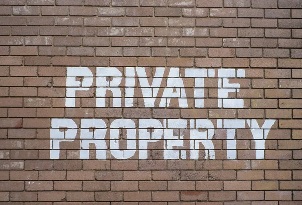 Private Property text sign on Brown Brick wall