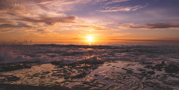 Amanecer pacífico desde el mar, cielo nublado dorado y gran ola — Foto de Stock