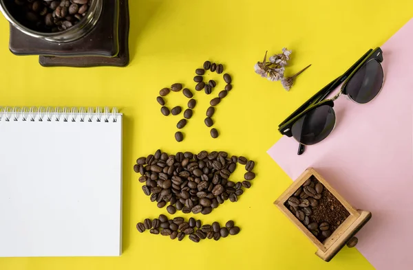 coffee beans and crushed coffee bean in vintage wooden coffee grinder on yellow background