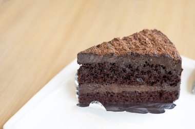 çikolatalı pasta dilimi, katman çikolata fudge beyaz tabakta, ahşap masa