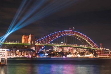 Avustralya - Sydney: 07 Haziran 2017. Sydney Harbour Bridge görüntülemek Circular quay parlak bulanık liman sularda yıllık canlı ışık Sydney Festivali 2017 sırasında yansıtan ışık ile aydınlatılmış üzerinden.