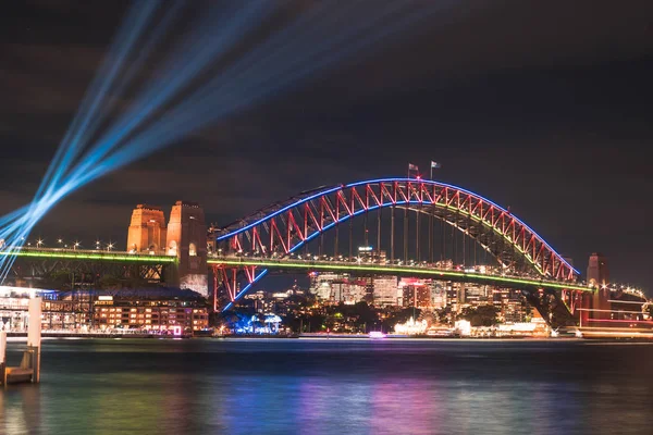 Avustralya - Sydney: 07 Haziran 2017. Sydney Harbour Bridge görüntülemek Circular quay parlak bulanık liman sularda yıllık canlı ışık Sydney Festivali 2017 sırasında yansıtan ışık ile aydınlatılmış üzerinden.