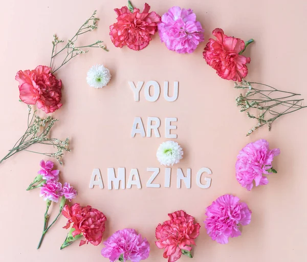 Minimal flat lay  you are amazing inspiration wooden word with fresh flowers wreath frame