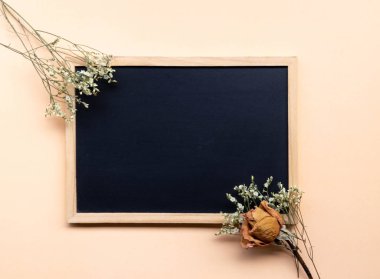 yumuşak krem zemin üzerine kurutulmuş gül desenli siyah tebeşir tahtası