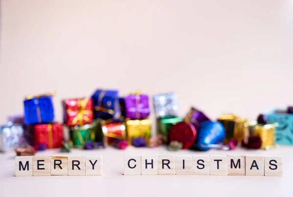 Frohe Weihnachten Wort Auf Holzblock Mit Bunten Weihnachtsgeschenkschachteln Hintergrund — Stockfoto