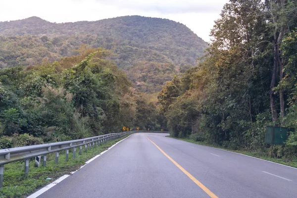 国の高速道路のカーブして山を緑の森で — ストック写真