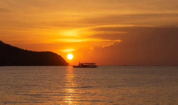 Silhouette bateau de pêcheur flottant sur la mer pendant le coucher de soleil doré — Photo