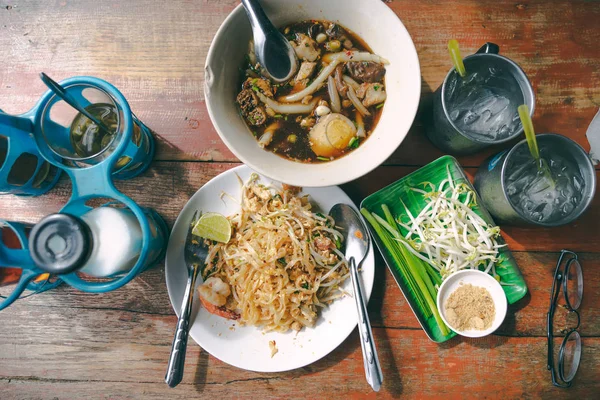 Nejlepší pohled Thajská ulice jídlo na starém dřevěném stole padthai a Guay j — Stock fotografie