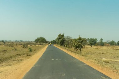Yaz sezonu sıcak bir öğleden sonra her iki düz karayolu kırsal yol küçük ağaçlar.