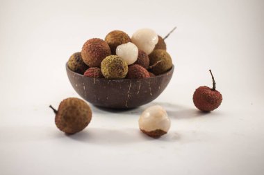 Lychee beyaz arka plan üzerinde ahşap bir kase. Lezzetli tropikal meyve.
