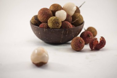Lychee beyaz arka plan üzerinde ahşap bir kase. Lezzetli tropikal meyve.