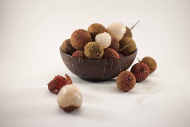 Lychee beyaz arka plan üzerinde ahşap bir kase. Lezzetli tropikal meyve.
