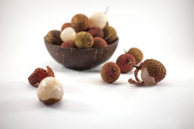 Lychee beyaz arka plan üzerinde ahşap bir kase. Lezzetli tropikal meyve.