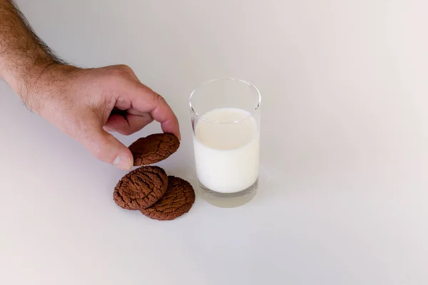 Yanında bir bardak süt çikolata kurabiye almak ulaşan el