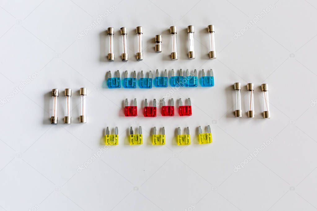 Small car fuses arranged on a white background