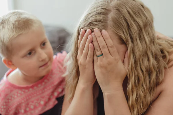 annesi için ilgili ve onun onun rahatlatıcı içine eğilerek genç çocuk ağlıyor