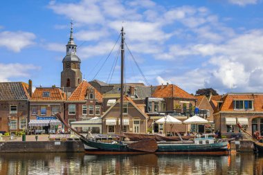 Blokzijl, Hollanda - 13 Temmuz 2017: Doğal liman ayrıntılı olarak Blokzijl tarihi köy eski düz dipli gemiler ve anıtsal ve kilise, Hollanda ile güneşli yaz gününde